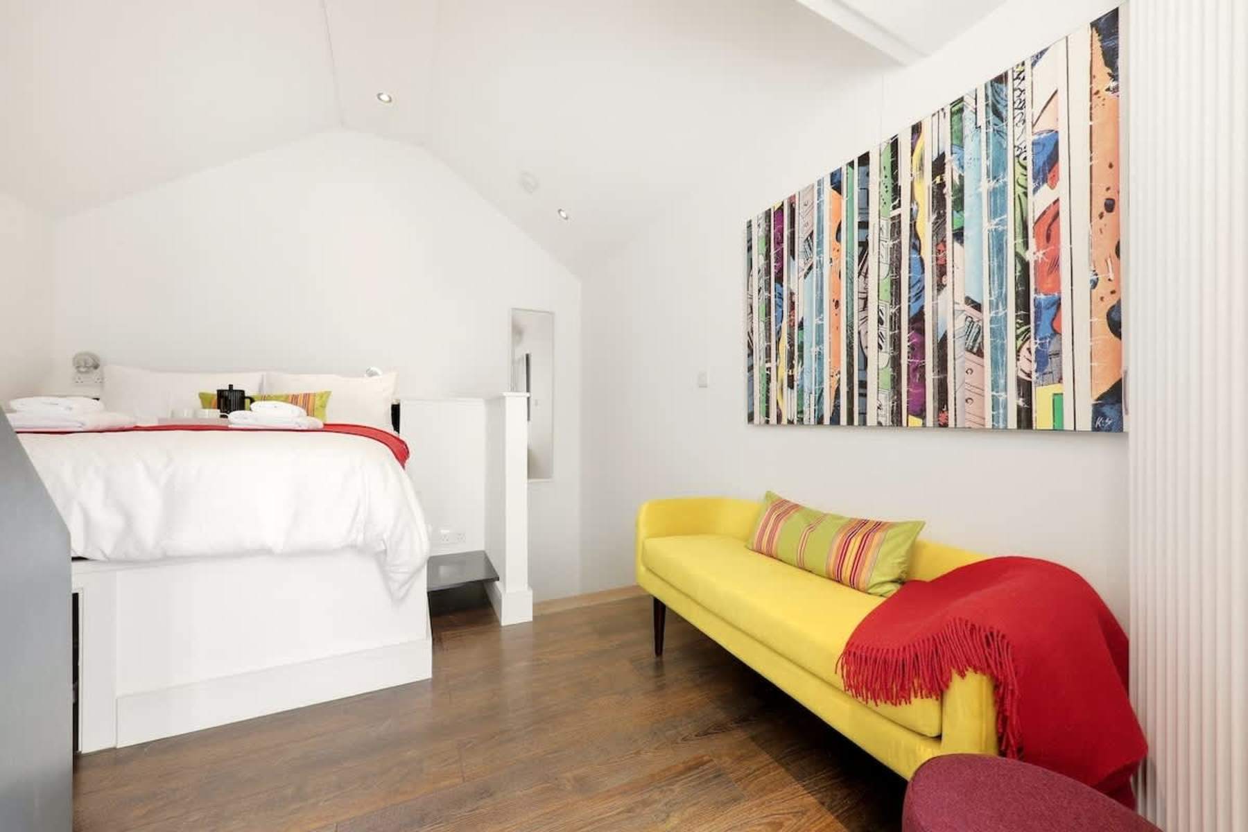 Bedroom with yellow sofa at The Coach House, Harrogate